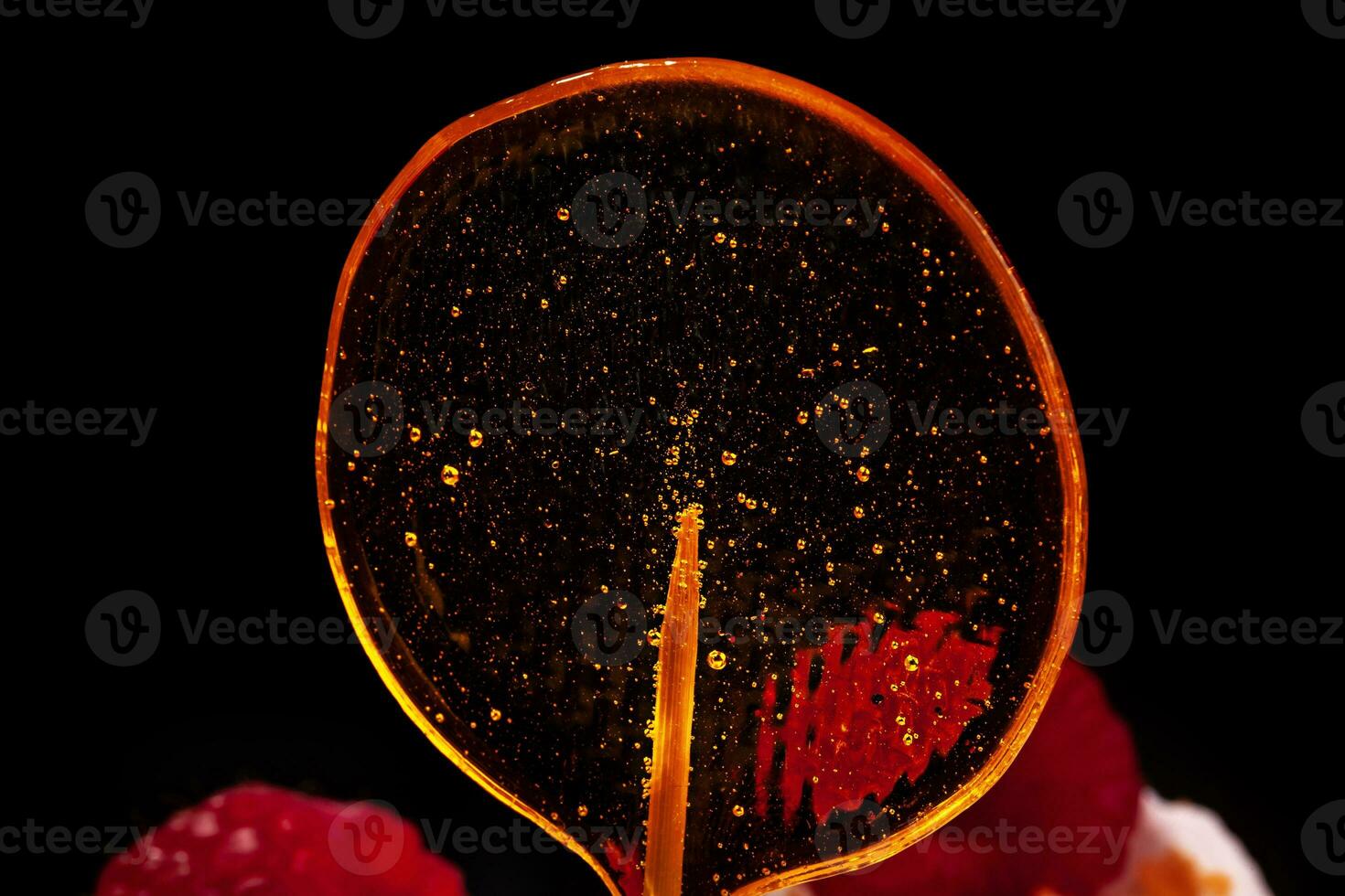 Cake in white glaze with fresh raspberry and lollipops on black background. Close-up photo