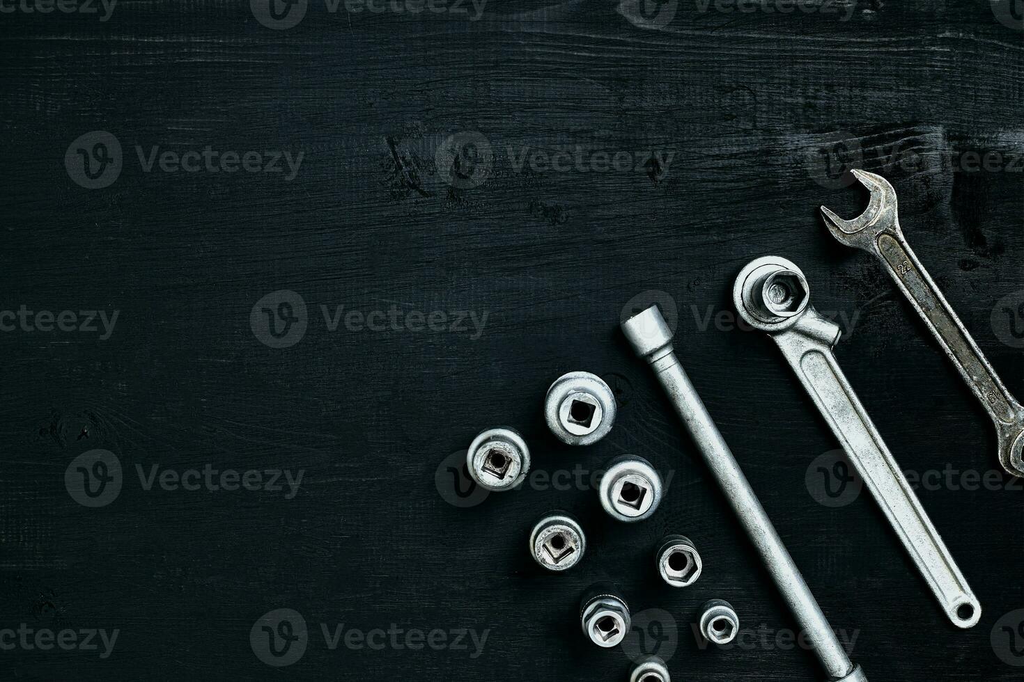 Tools for car repair in Workshop. Car repair equipment on black wooden background in car repair shop photo