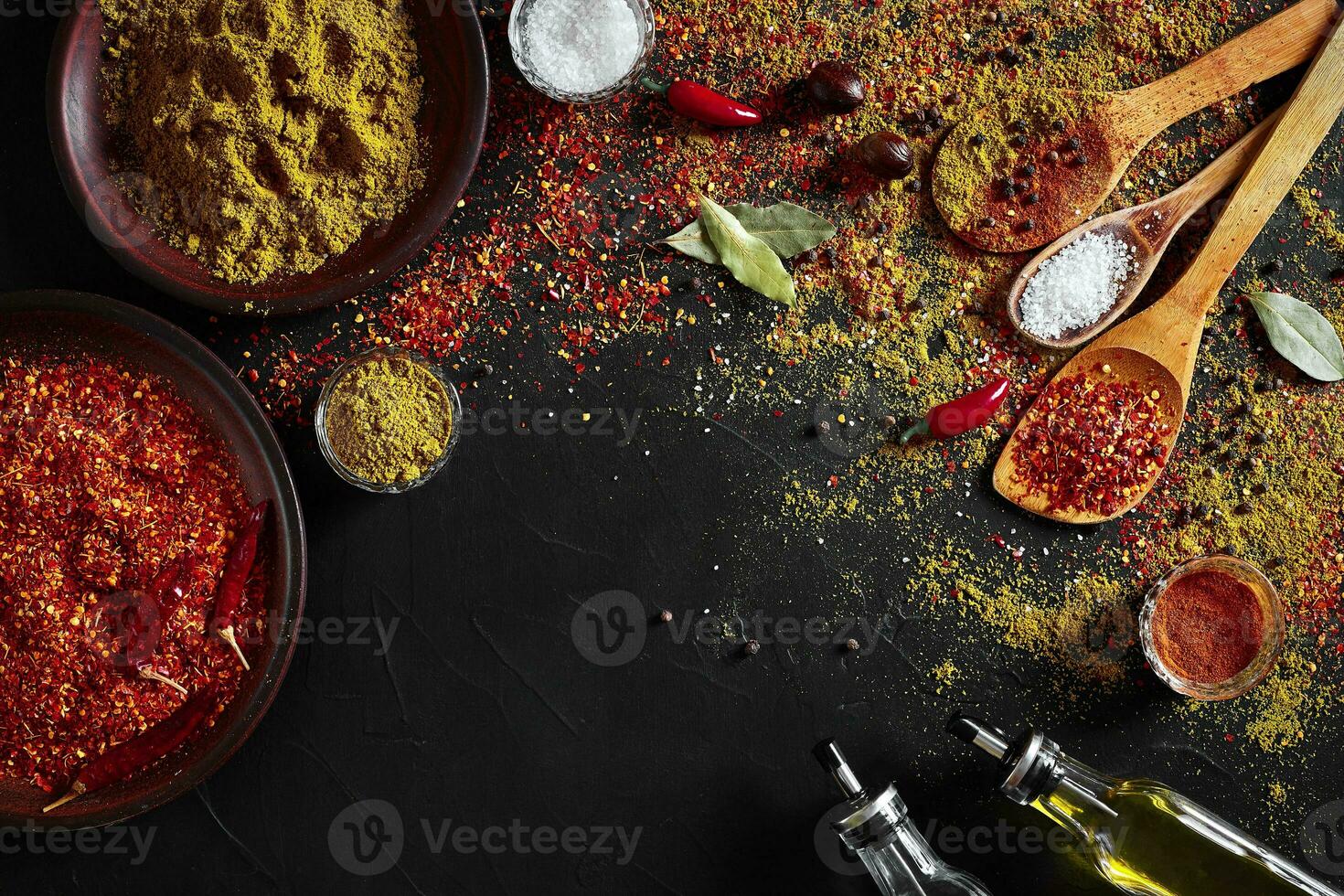Set of indian spices on black background - green cardamom, turmeric powder, coriander seeds, cumin, and chili, top view photo