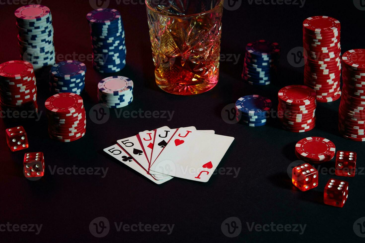 Cards of poker player. On the table are chips and a glass of cocktail with whiskey. Combination of cards photo