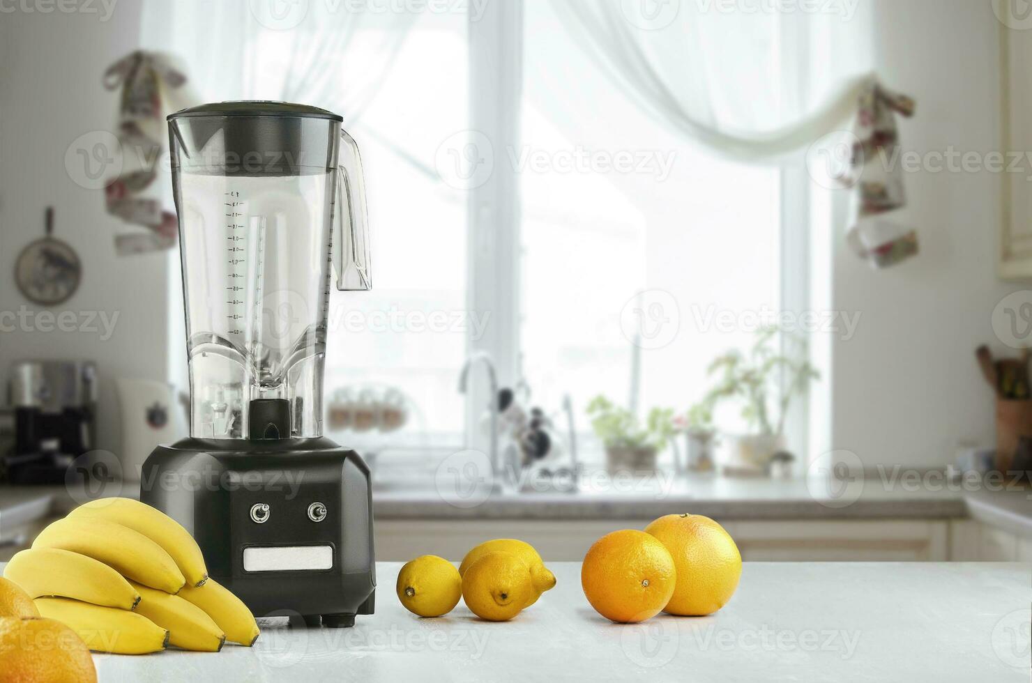 Metal food blender close-up with fresh exotic tropic fruits next to it on kitchen background with empty space photo