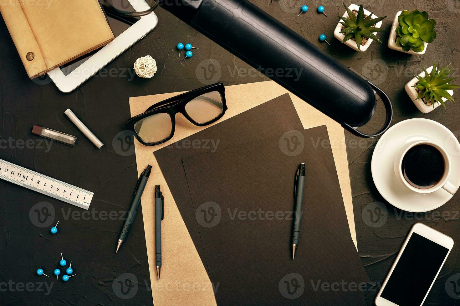 Engineer's desk in office with various gadgets and documents photo