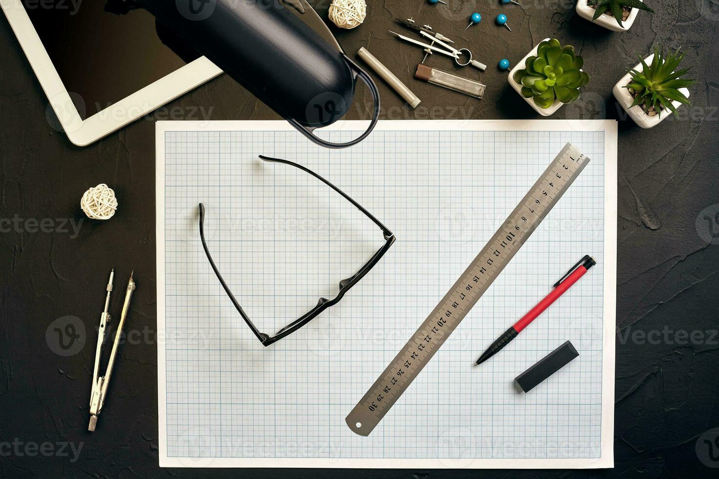 Top view of the builder's workplace, ruler, paper for drawings, compasses, glasses, tablet photo