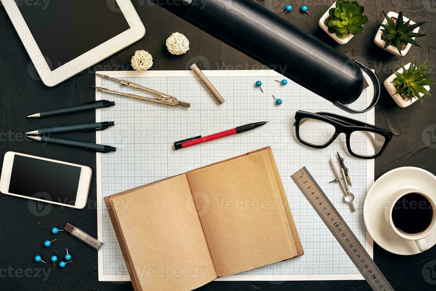 Engineer's desk in office with various gadgets and documents photo