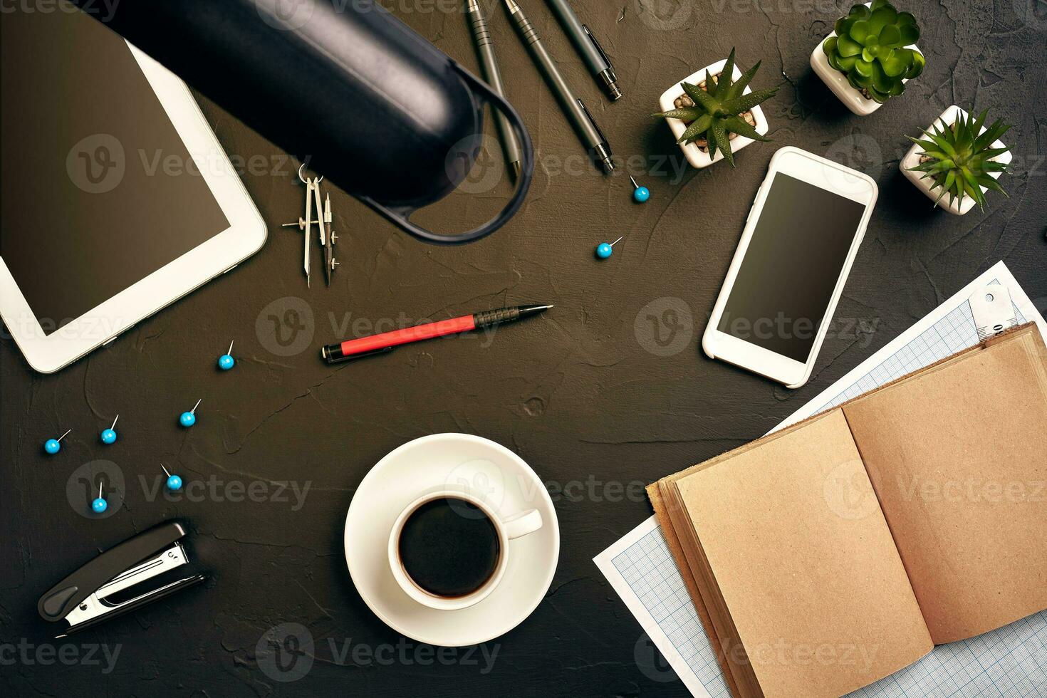 Engineer's desk in office with various gadgets and documents photo