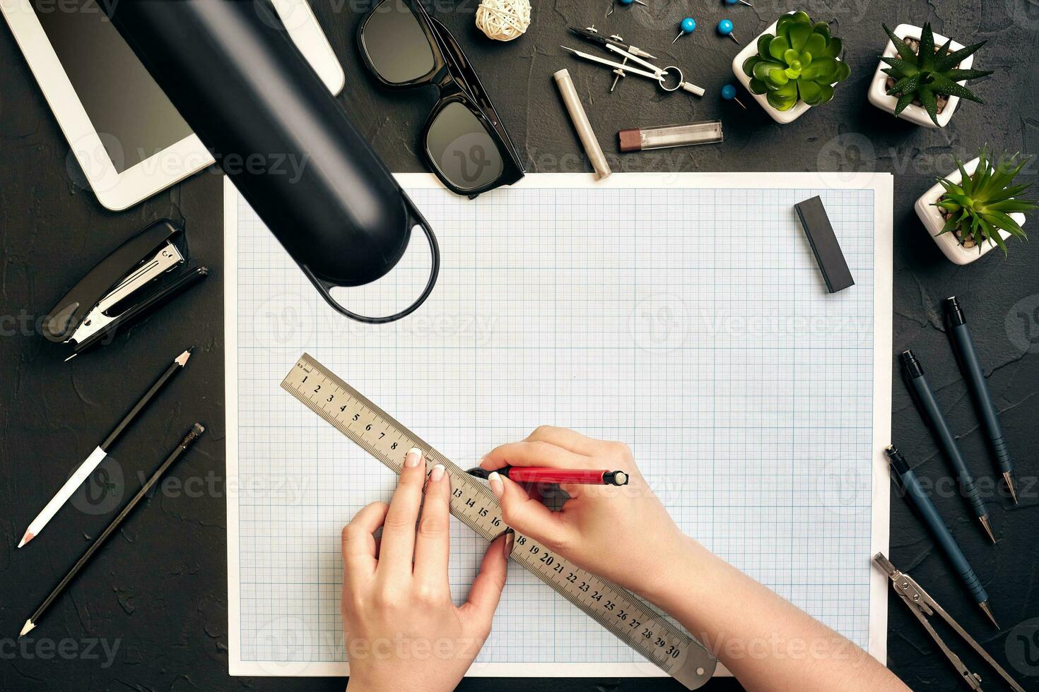 Office desk background hand with pen writing construction project ideas concept, With tablet, drawing equipment and lamp. View from above photo