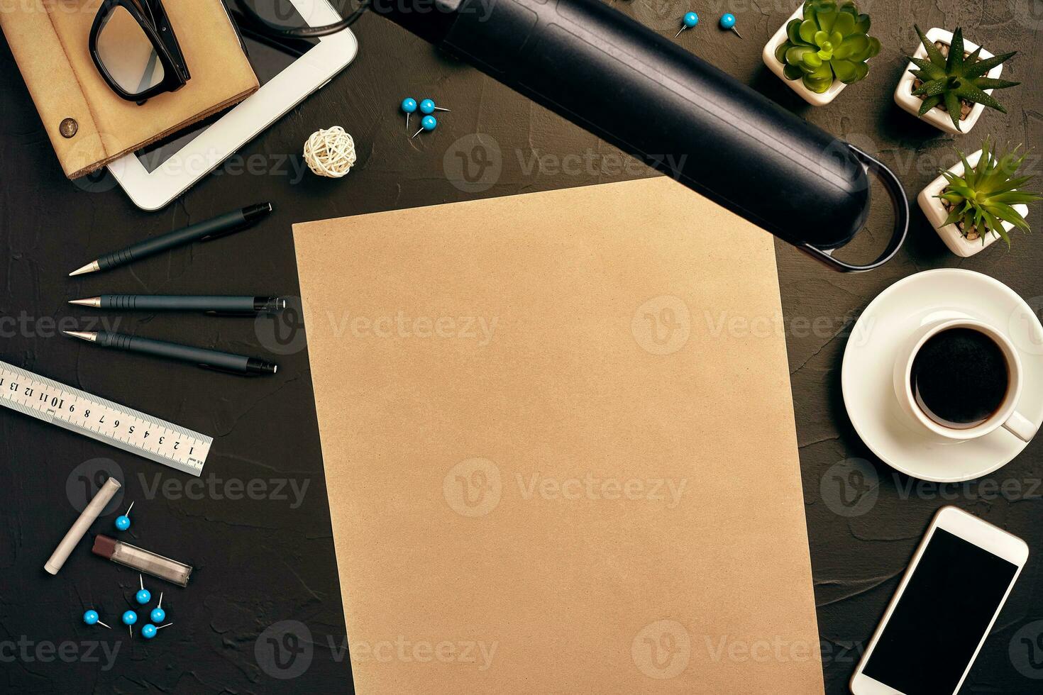 Engineer's desk in office with various gadgets and documents photo