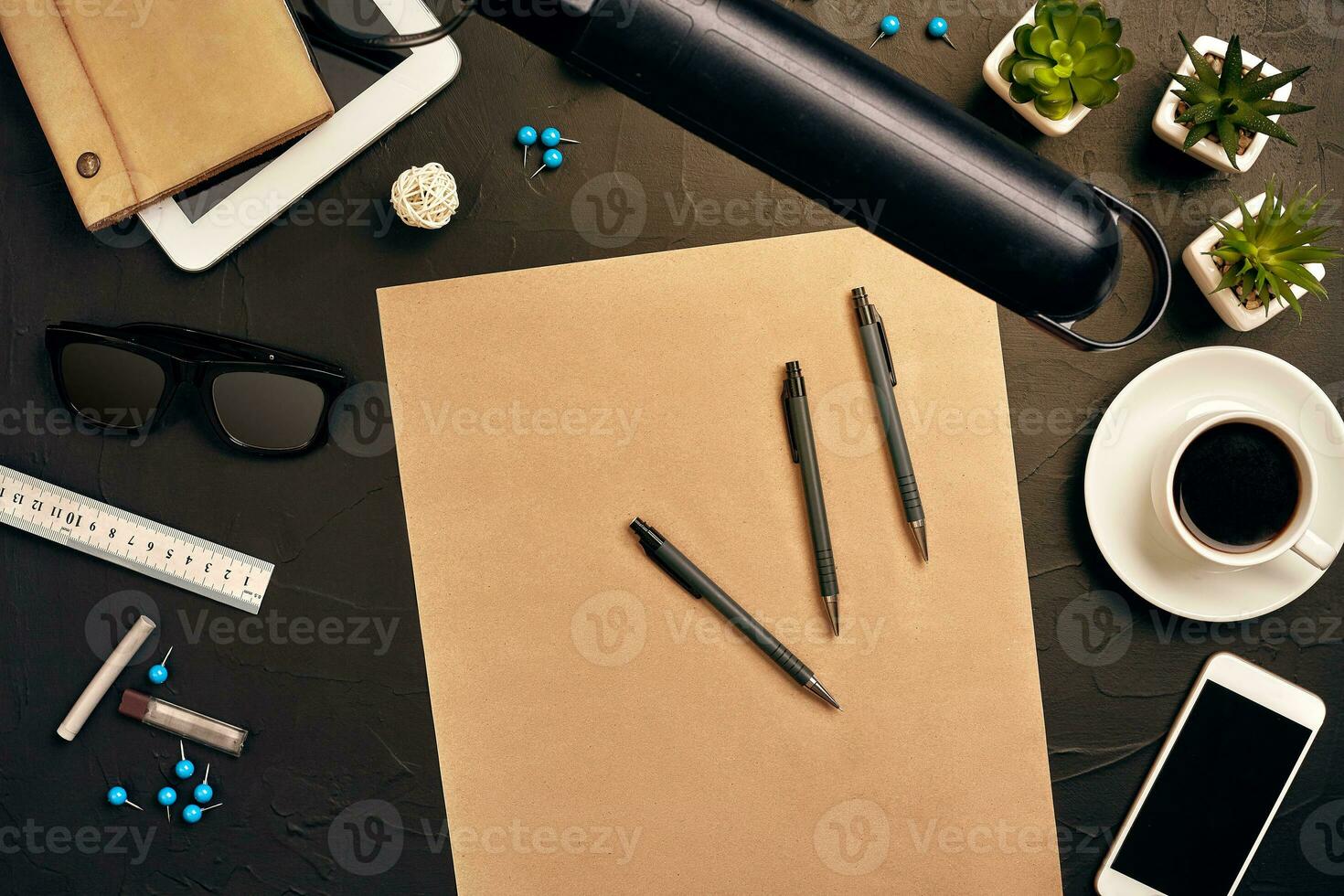 Engineer's desk in office with various gadgets and documents photo