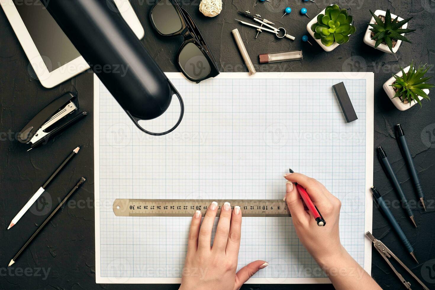 Office desk background hand with pen writing construction project ideas concept, With tablet, drawing equipment and lamp. View from above photo