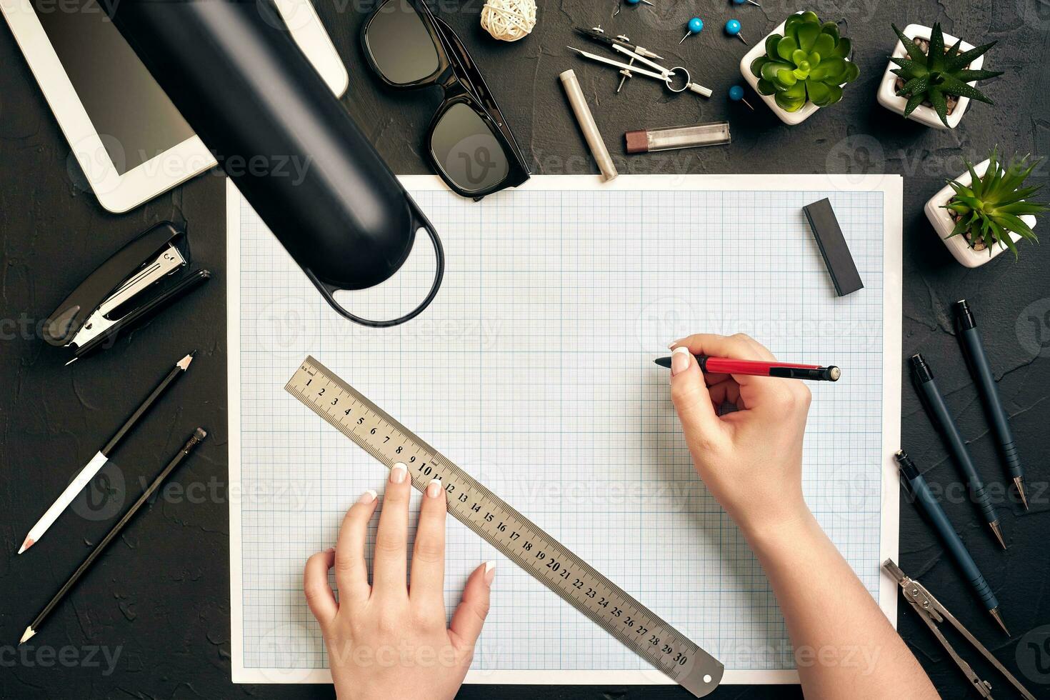 Office desk background hand with pen writing construction project ideas concept, With tablet, drawing equipment and lamp. View from above photo