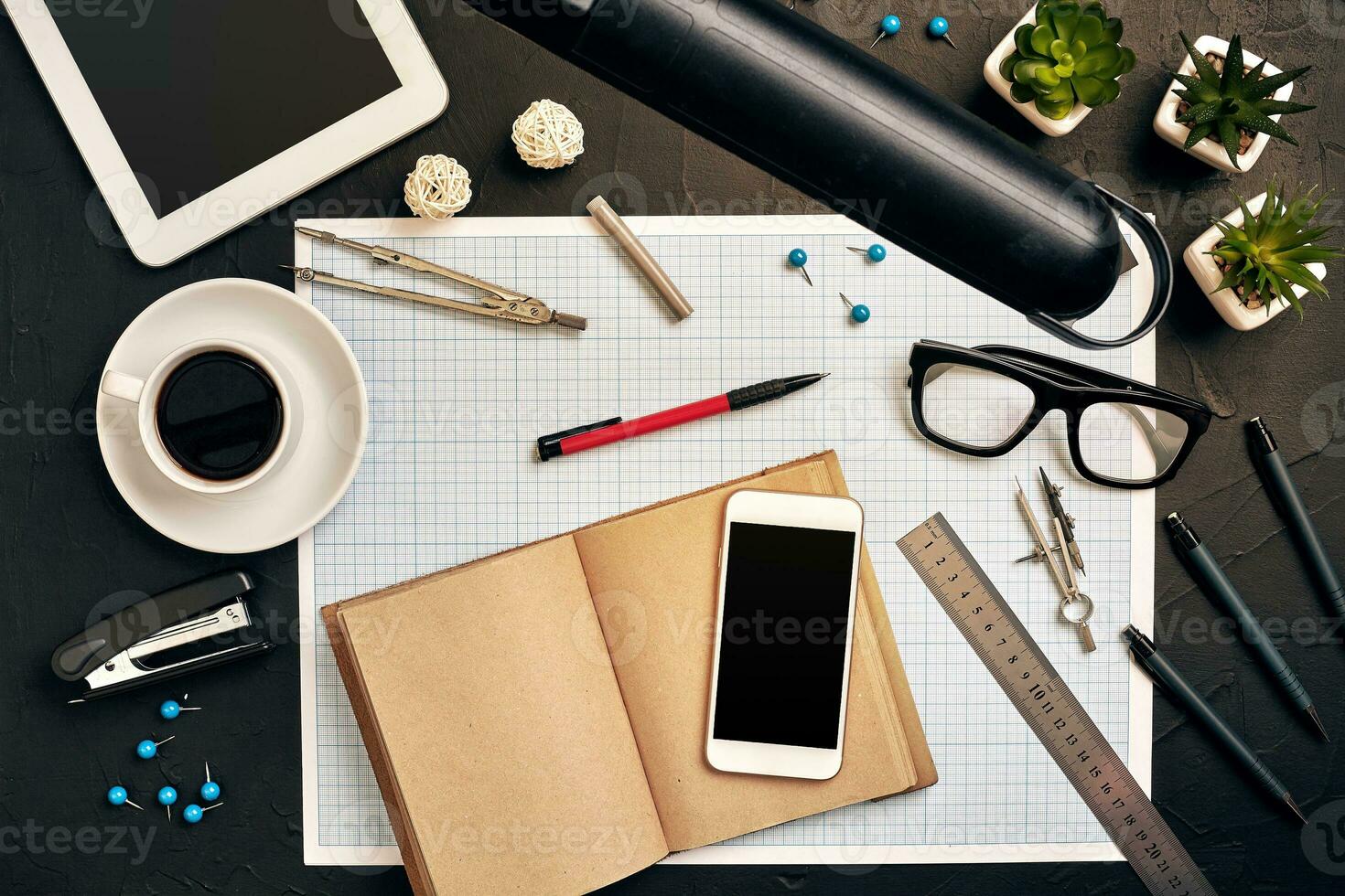 Engineer's desk in office with various gadgets and documents photo