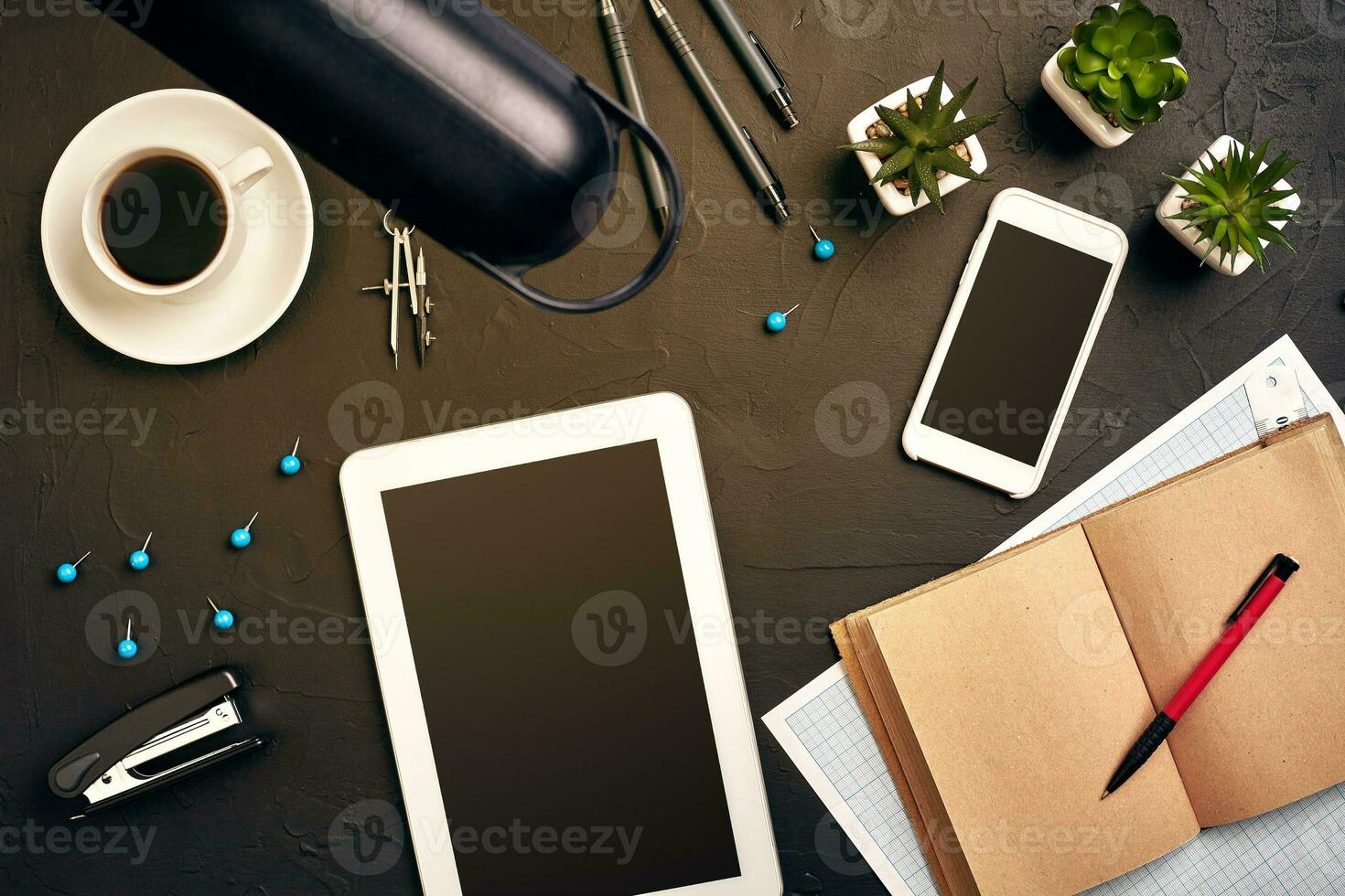 Engineer's desk in office with various gadgets and documents photo
