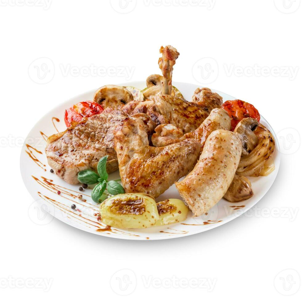 Close-up photo of mixed grilled meat platter. Beef, pork, poultry, sausages, grilled garlic, chili pepper, red tomatoes on white background.