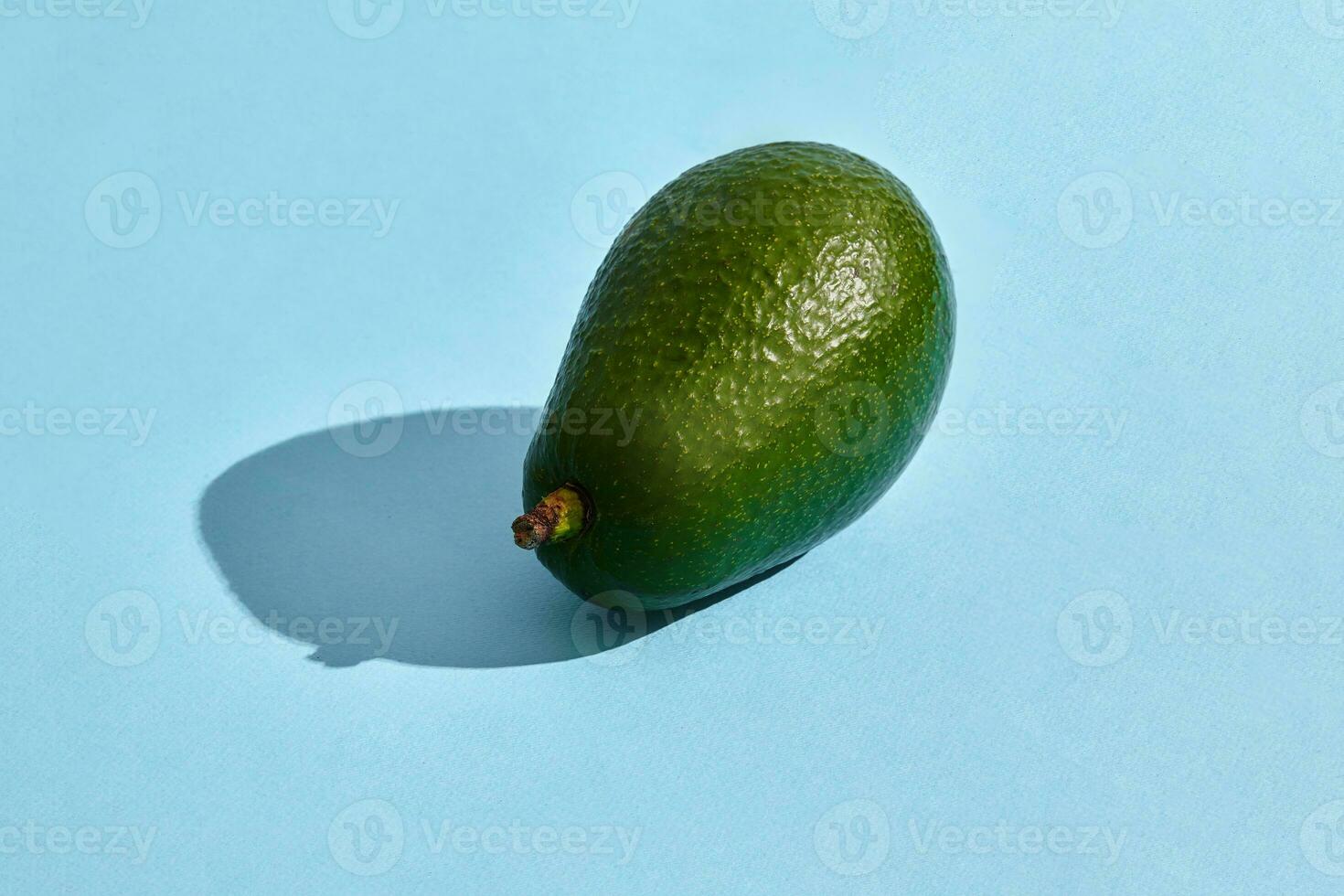 Close up high quality image of whole avocado, fruit composition on blue pastel photo