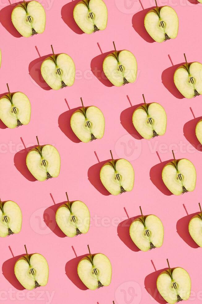 vistoso Fruta modelo de Fresco cortado manzana mitades con pozos en coral rosado fondo, parte superior ver foto