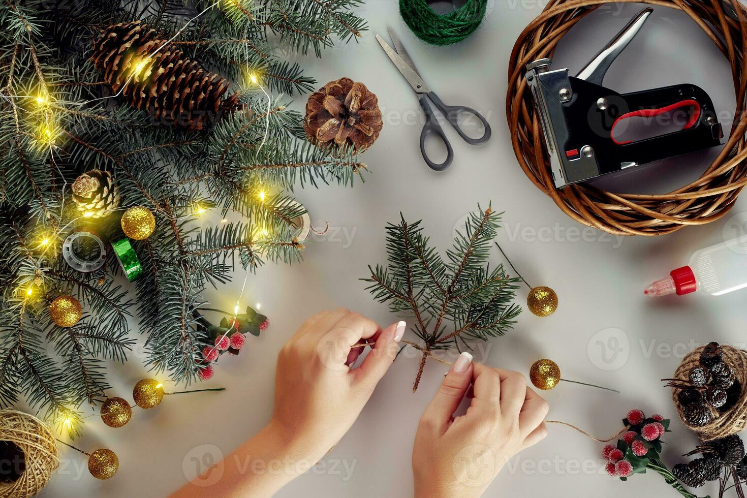 Christmas background with decorations, garland and pine cones. Creating wreath made of christmas tree branches on white background. photo