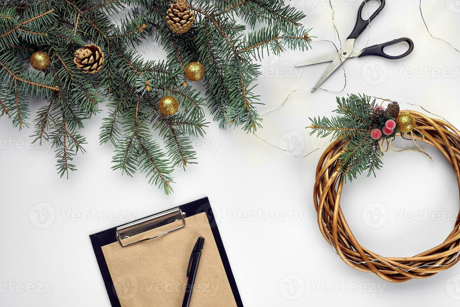 Creative christmas diy. Woman making handmade xmas wreath. Home leisure, tools, trinkets and details for holiday decorations on white table background. Top view photo
