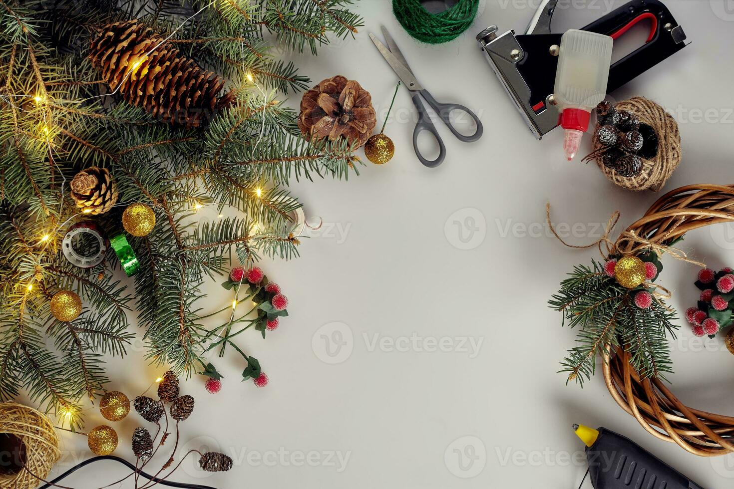 Creative christmas diy. Woman making handmade xmas wreath. Home leisure, tools, trinkets and details for holiday decorations on white table background. Top view photo