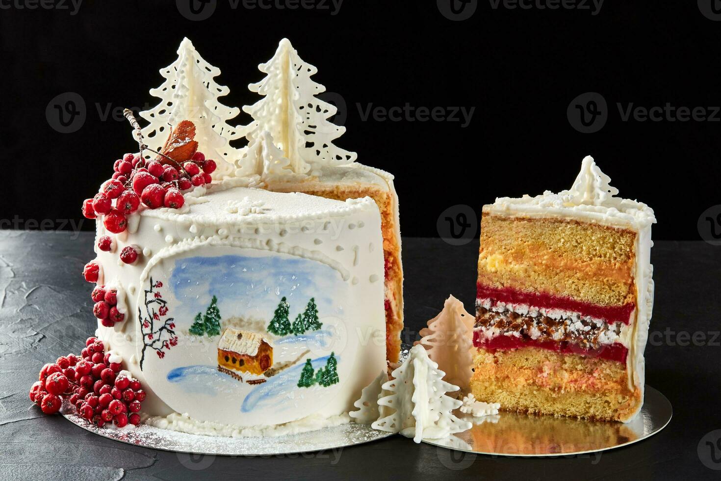 Winter cake covered with white icing, with painted house in the forest, trees and red rowan. photo