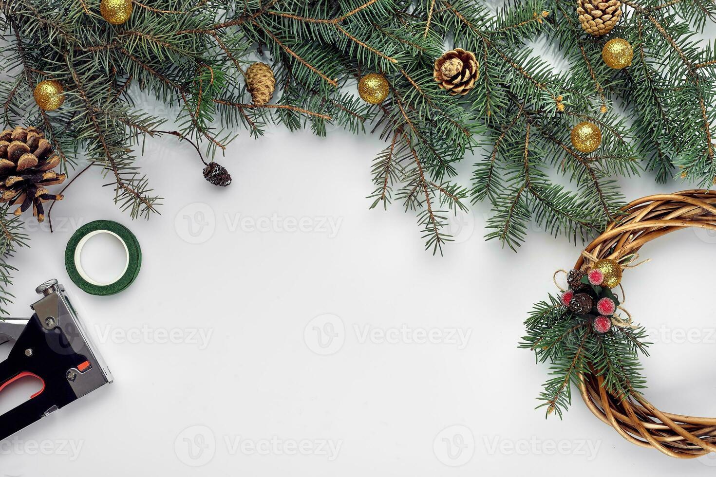 Creative christmas diy. Woman making handmade xmas wreath. Home leisure, tools, trinkets and details for holiday decorations on white table background. Top view photo