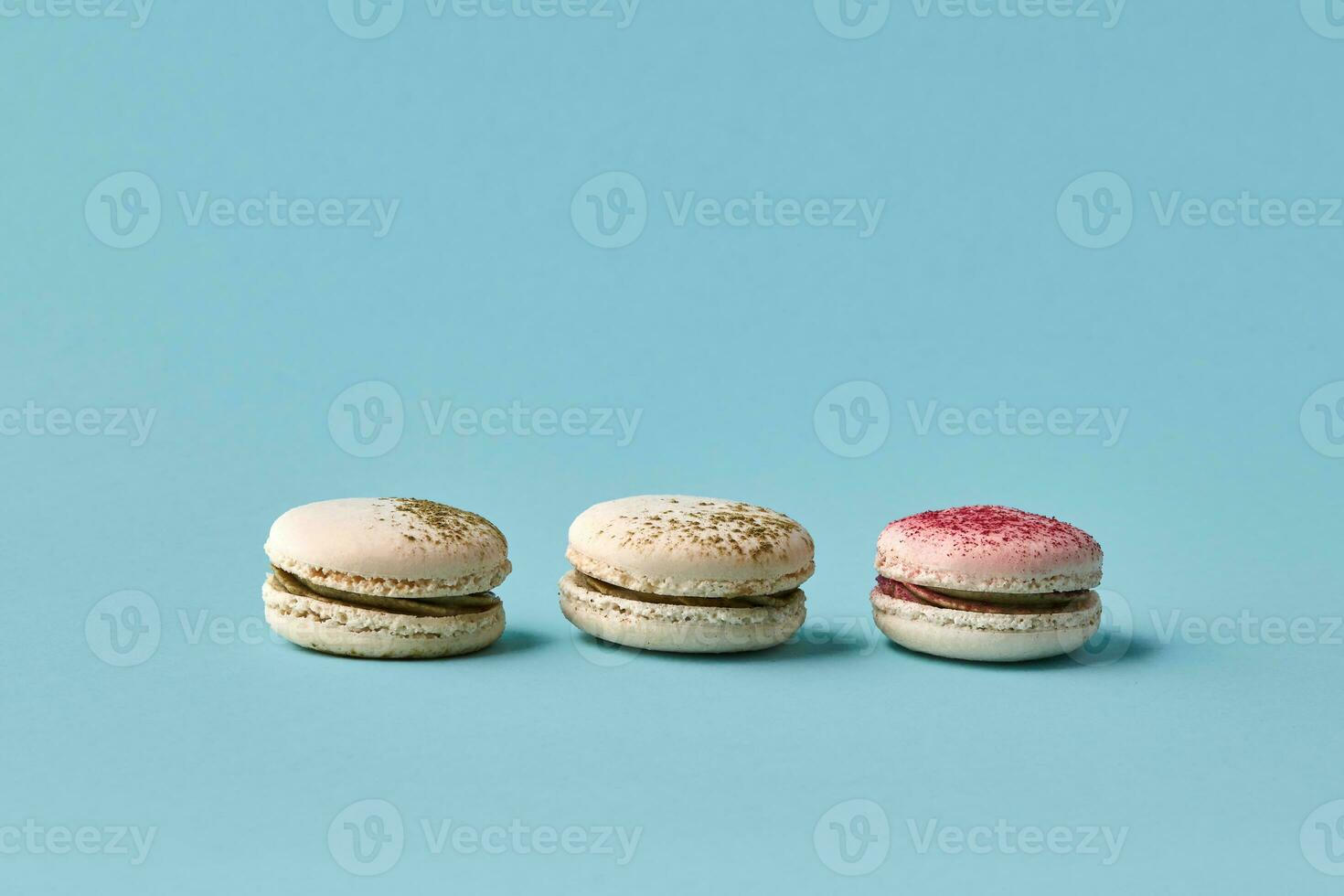 White macarons cake with colorful powder, top view, flat lay, sweet macaroon on blue background. photo