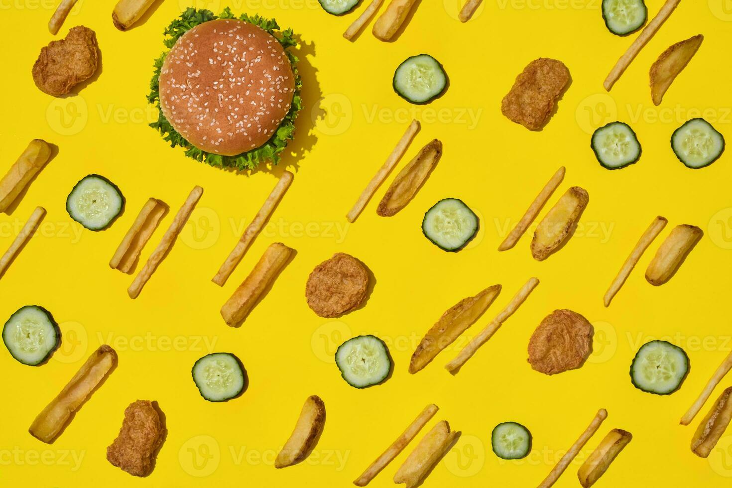 Most popular fast food meal. Chicken nuggets, burger and french fries on yellow background top view photo