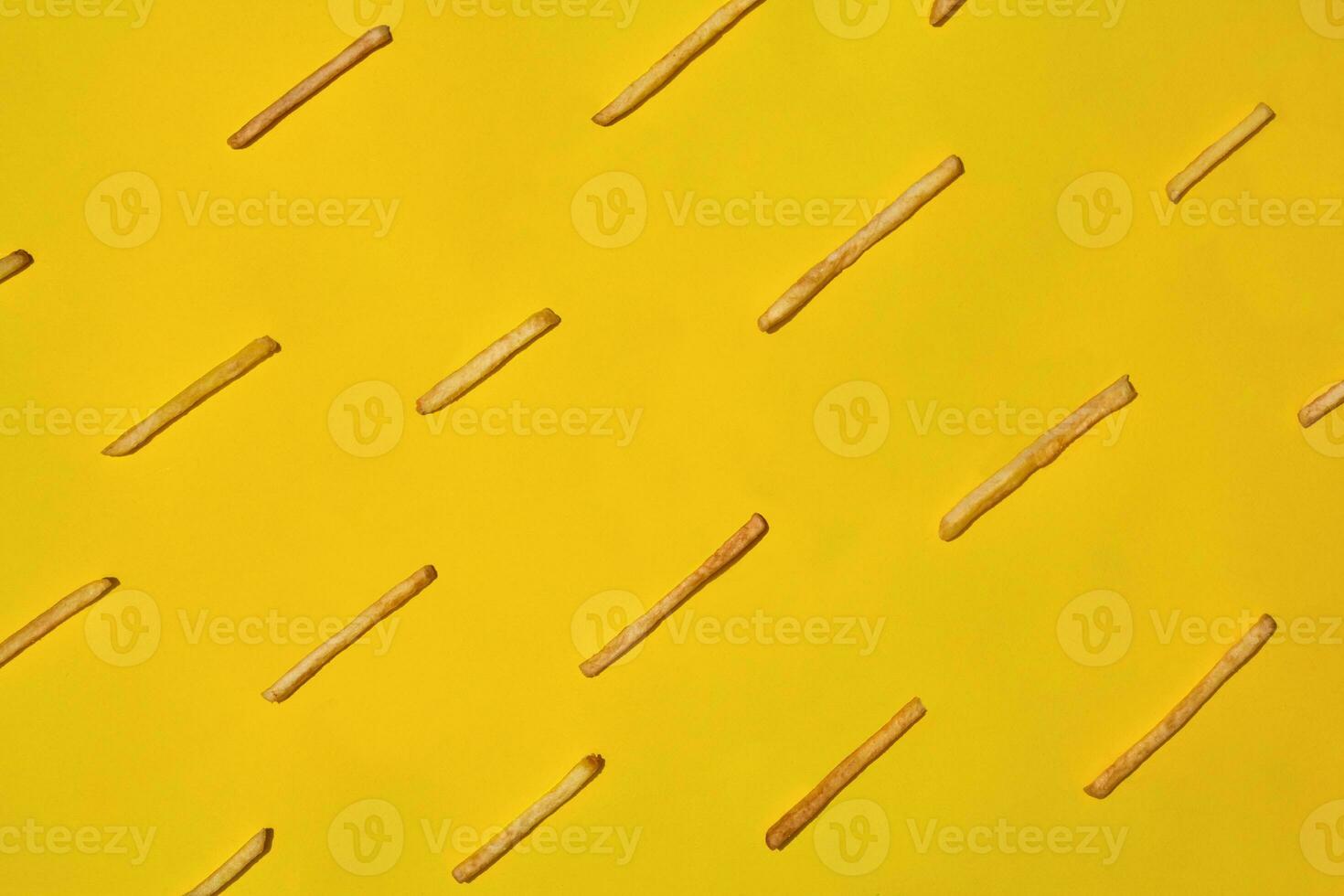 Heap of french fries on yellow background, top view photo