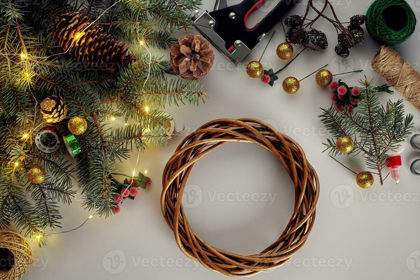 Christmas background with decorations, garland and pine cones. Creating wreath made of christmas tree branches on white background. photo