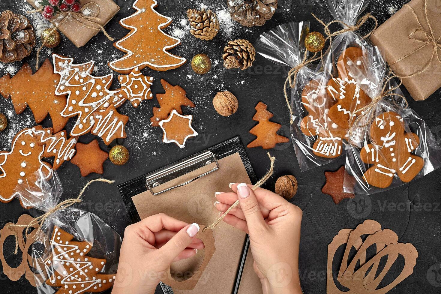 Christmas cookie tree made with star cookie cutter gingerbread new year pastry decorated with rope bow and form for cutting out cookies on black table. photo