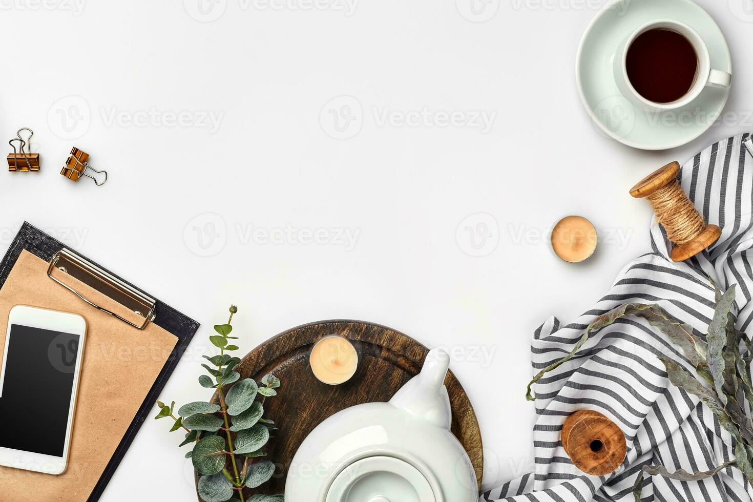 Still life with tea cup and the contents of a workspace composed. Different objects on white table. Flat lay photo