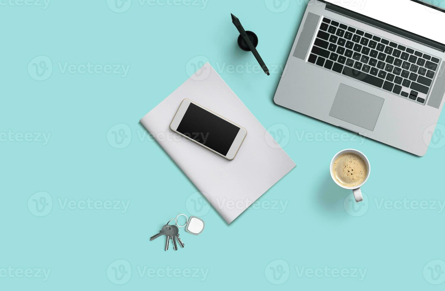 Office desk table with laptop computer, smartphone with black screen over a notebook and cup of coffee. Top view. photo