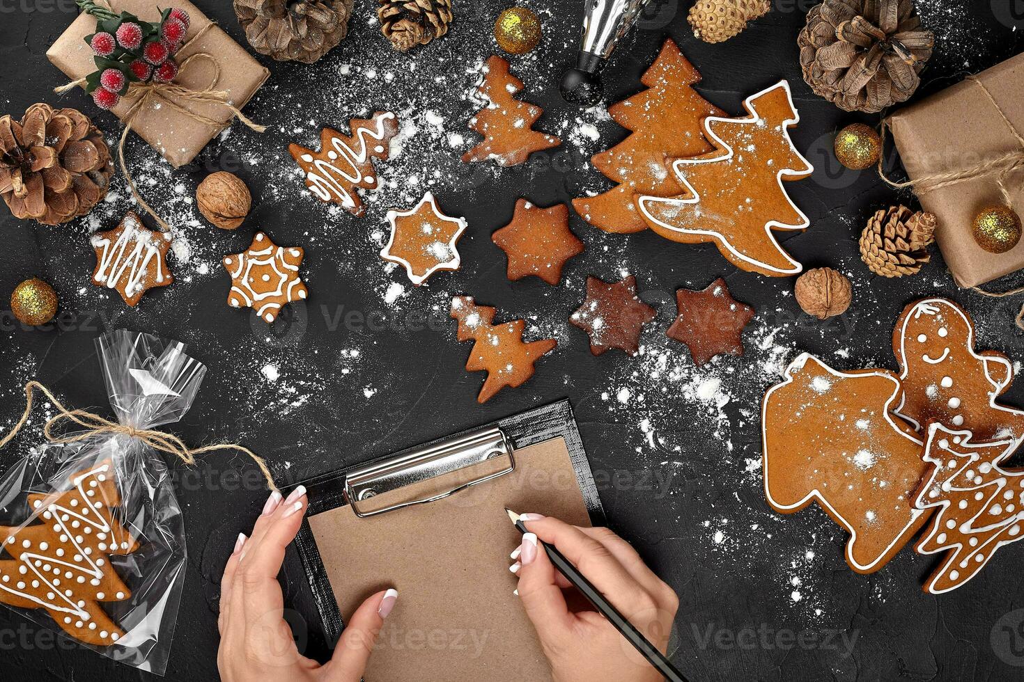 Christmas cookie tree made with star cookie cutter gingerbread new year pastry decorated with rope bow and form for cutting out cookies on black table. photo