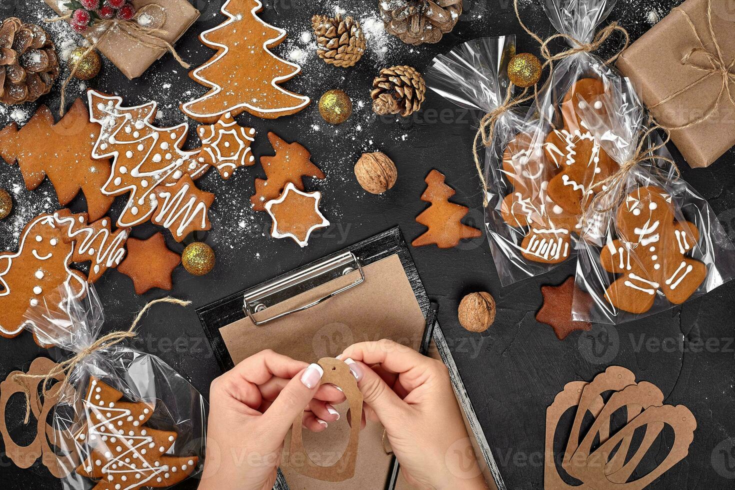 Christmas cookie tree made with star cookie cutter gingerbread new year pastry decorated with rope bow and form for cutting out cookies on black table. photo