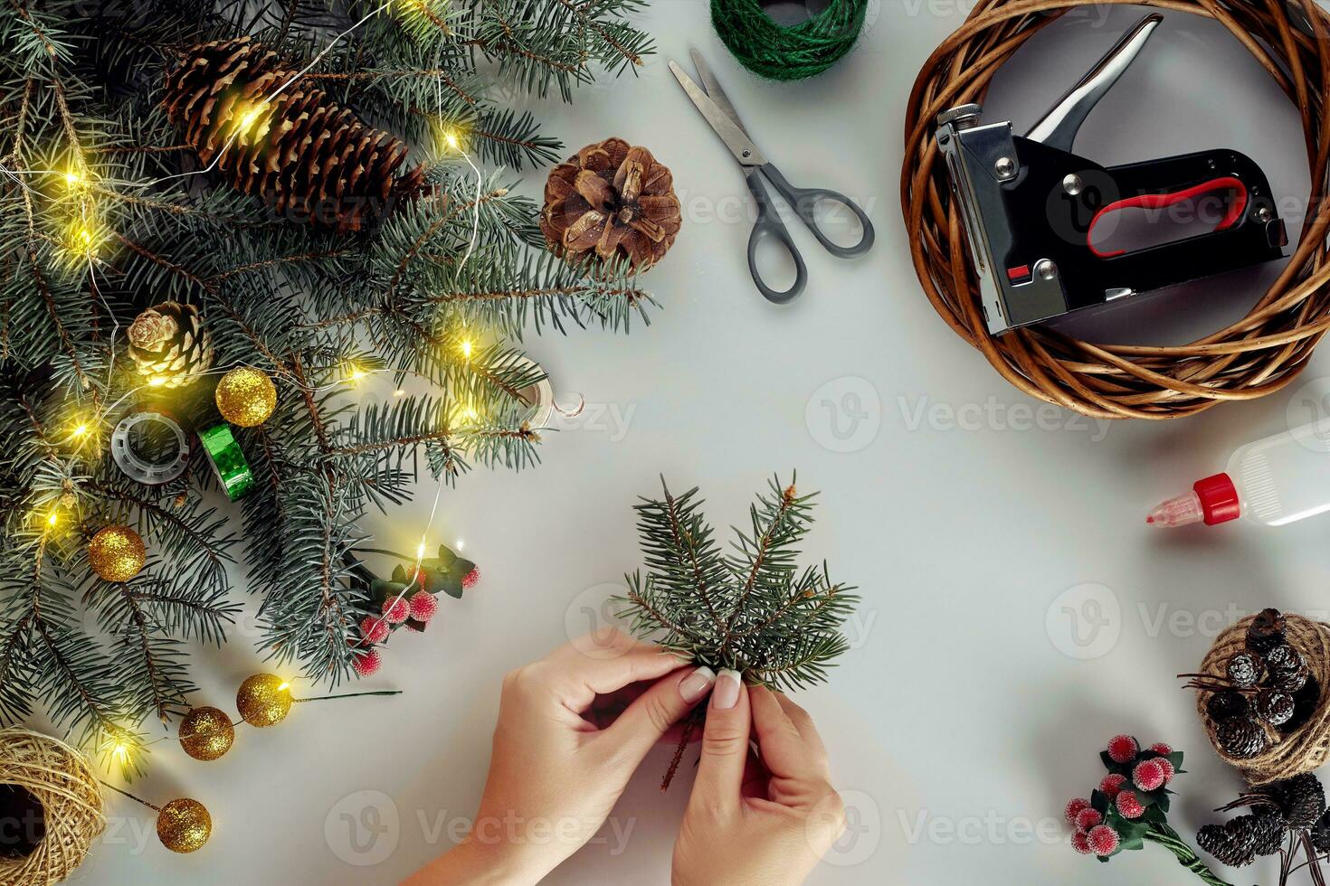 Christmas background with decorations, garland and pine cones. Creating wreath made of christmas tree branches on white background. photo
