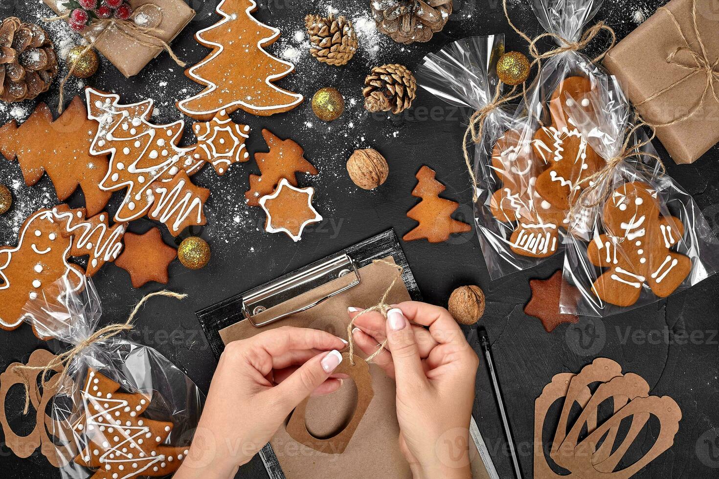 Christmas cookie tree made with star cookie cutter gingerbread new year pastry decorated with rope bow and form for cutting out cookies on black table. photo