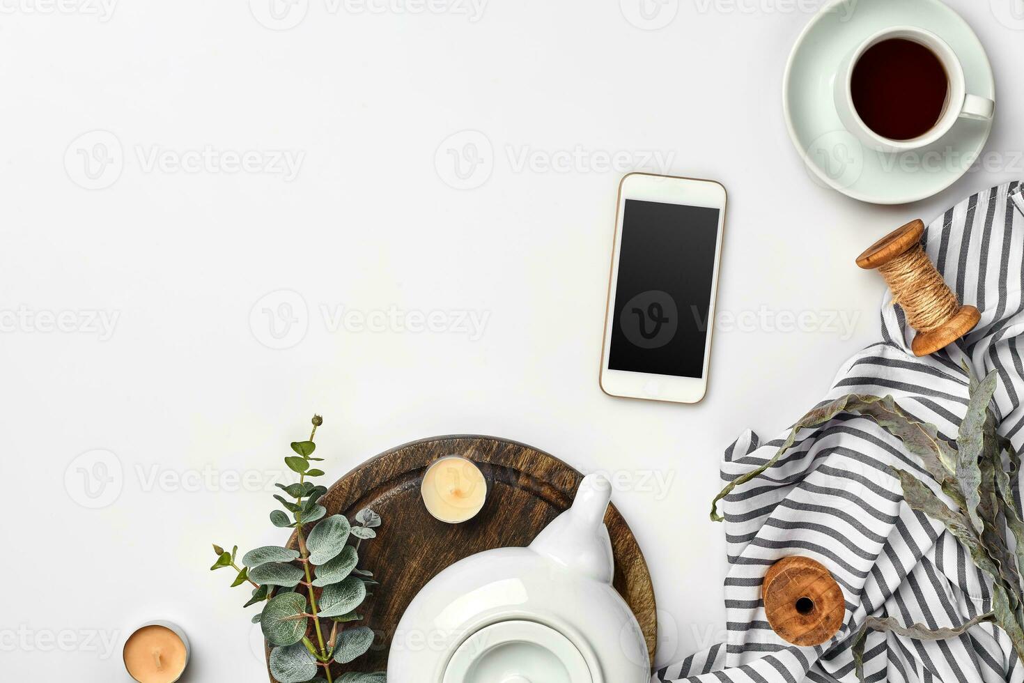 Still life with tea cup and the contents of a workspace composed. Different objects on white table. Flat lay photo