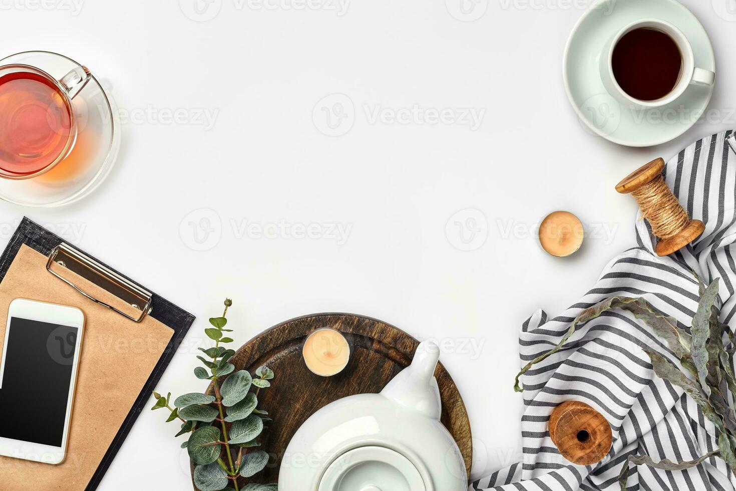 Still life with tea cup and the contents of a workspace composed. Different objects on white table. Flat lay photo