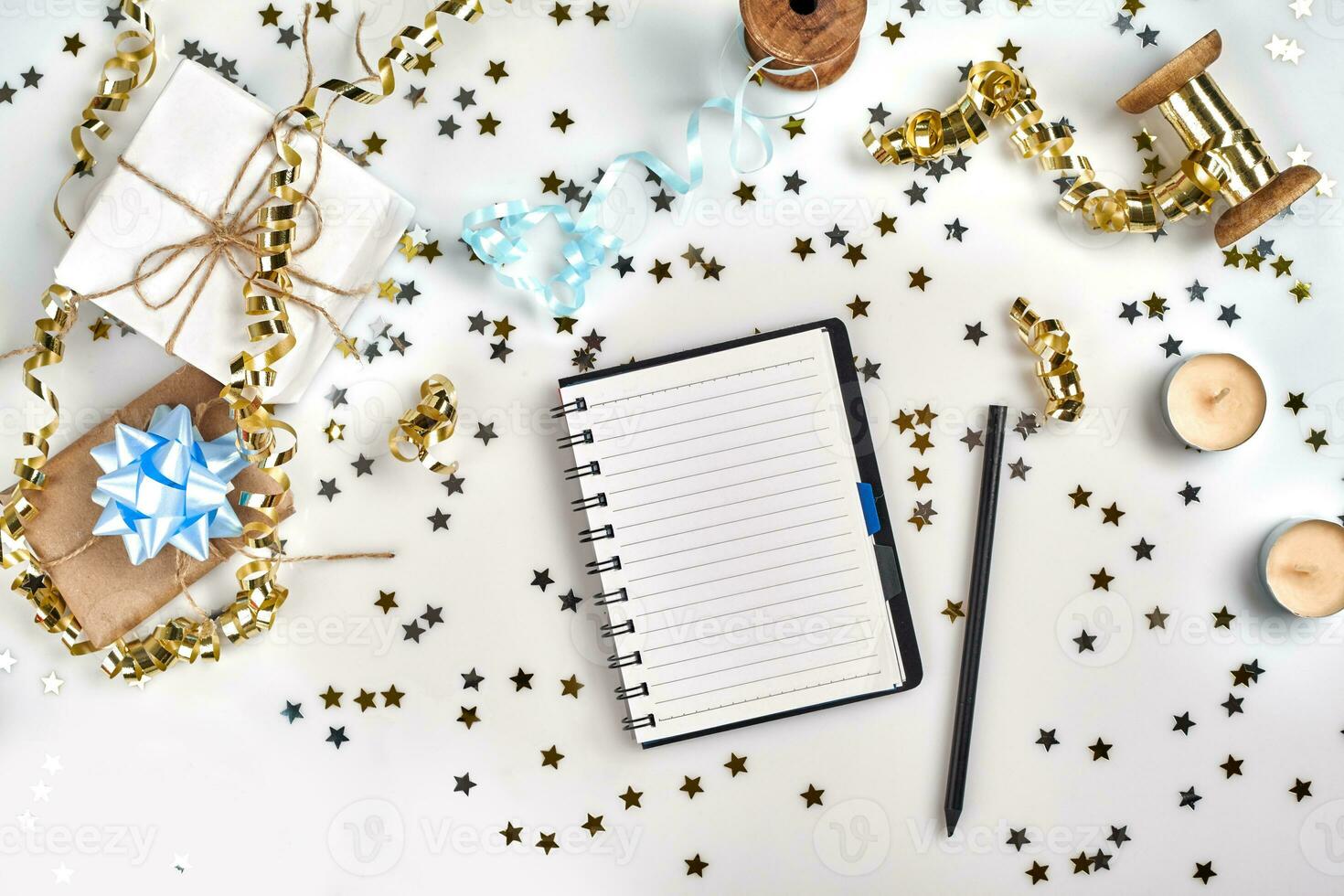 Flat Lay Christmas or Party Background with colored ribbons, decorations, confetti, and wrapping paper. Notepad for Text in Middle. photo