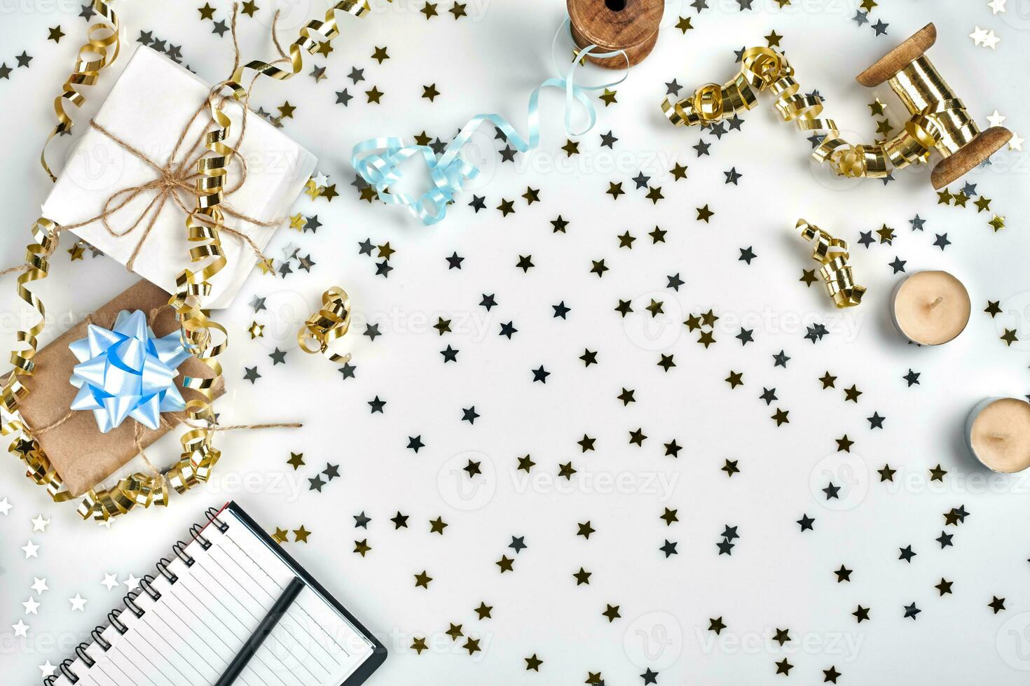 Flat Lay Christmas or Party Background with colored ribbons, decorations, confetti, and wrapping paper. Notepad for Text photo