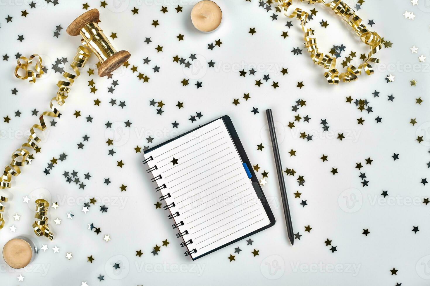 Flat Lay Christmas or Party Background with colored ribbons, decorations, confetti, and wrapping paper. Notepad for Text in Middle. photo