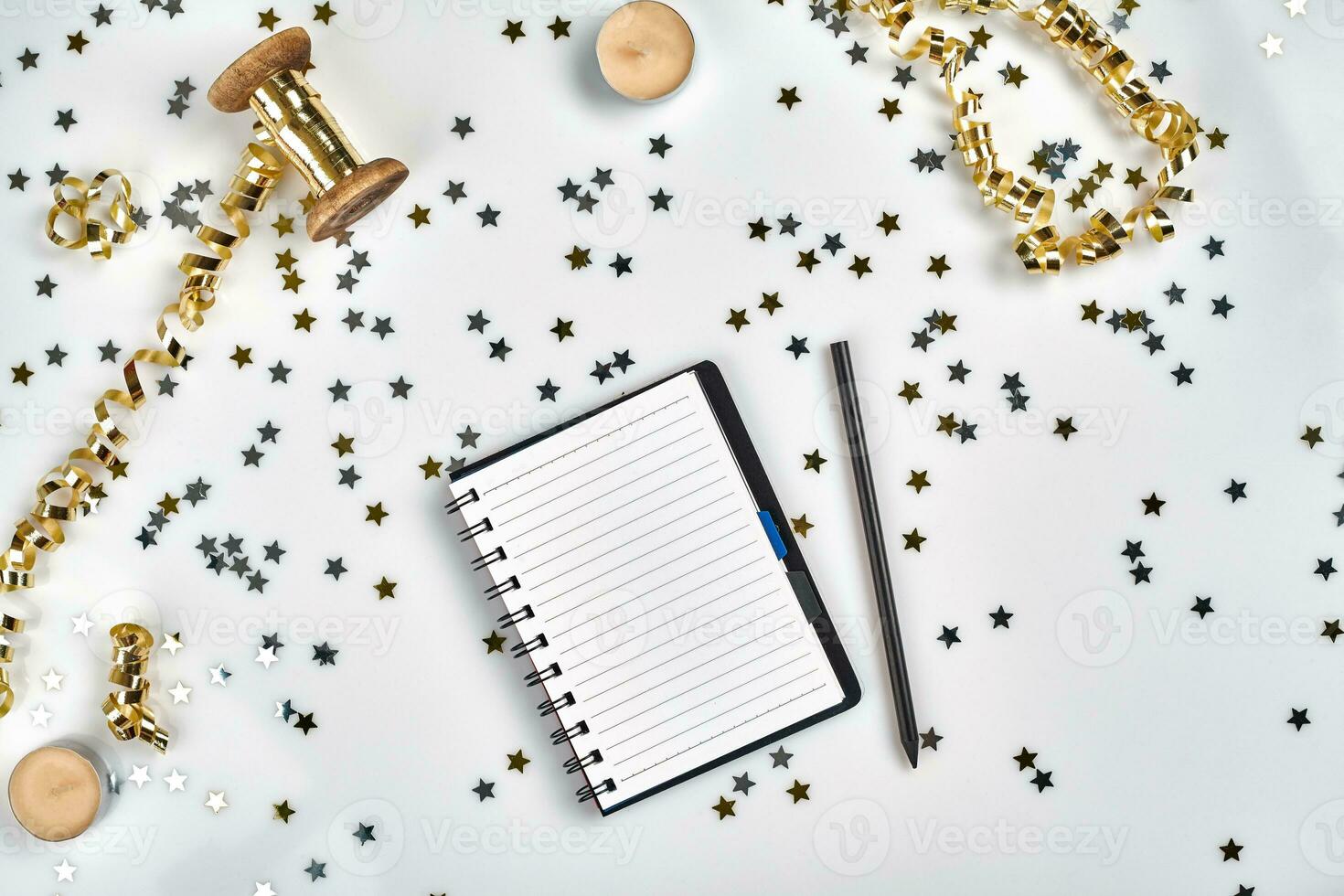 Flat Lay Christmas or Party Background with colored ribbons, decorations, confetti, and wrapping paper. Notepad for Text in Middle. photo