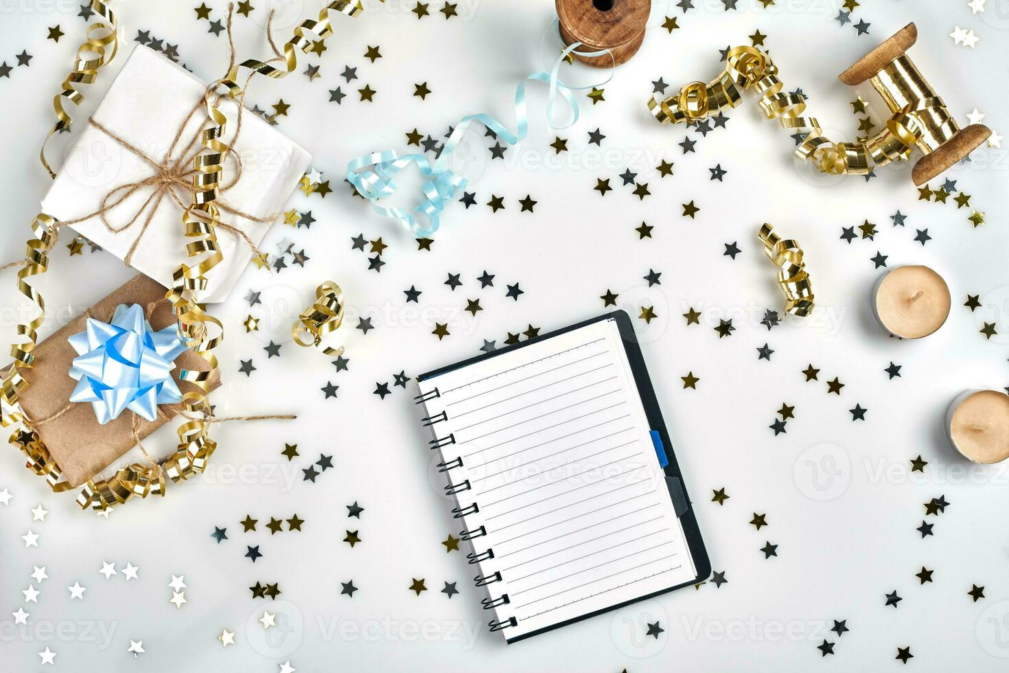 Flat Lay Christmas or Party Background with colored ribbons, decorations, confetti, and wrapping paper. Notepad for Text in Middle. photo