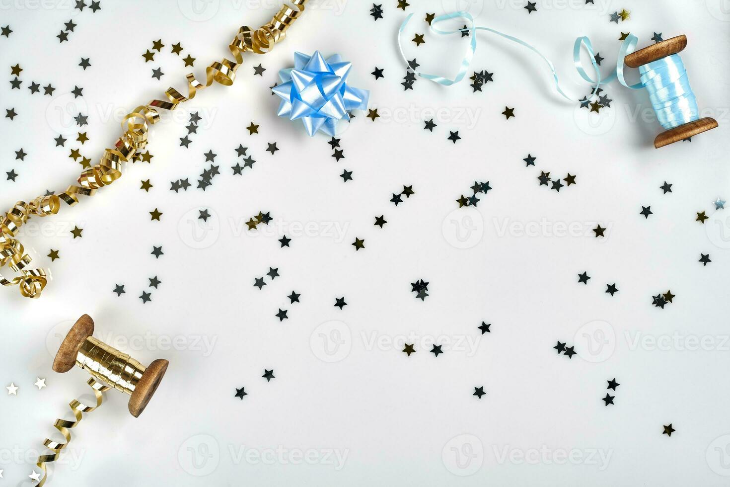 Delicate wavy ribbons and metallic star shaped confetti isolated on white background. Christmas holidays decoration concept. photo