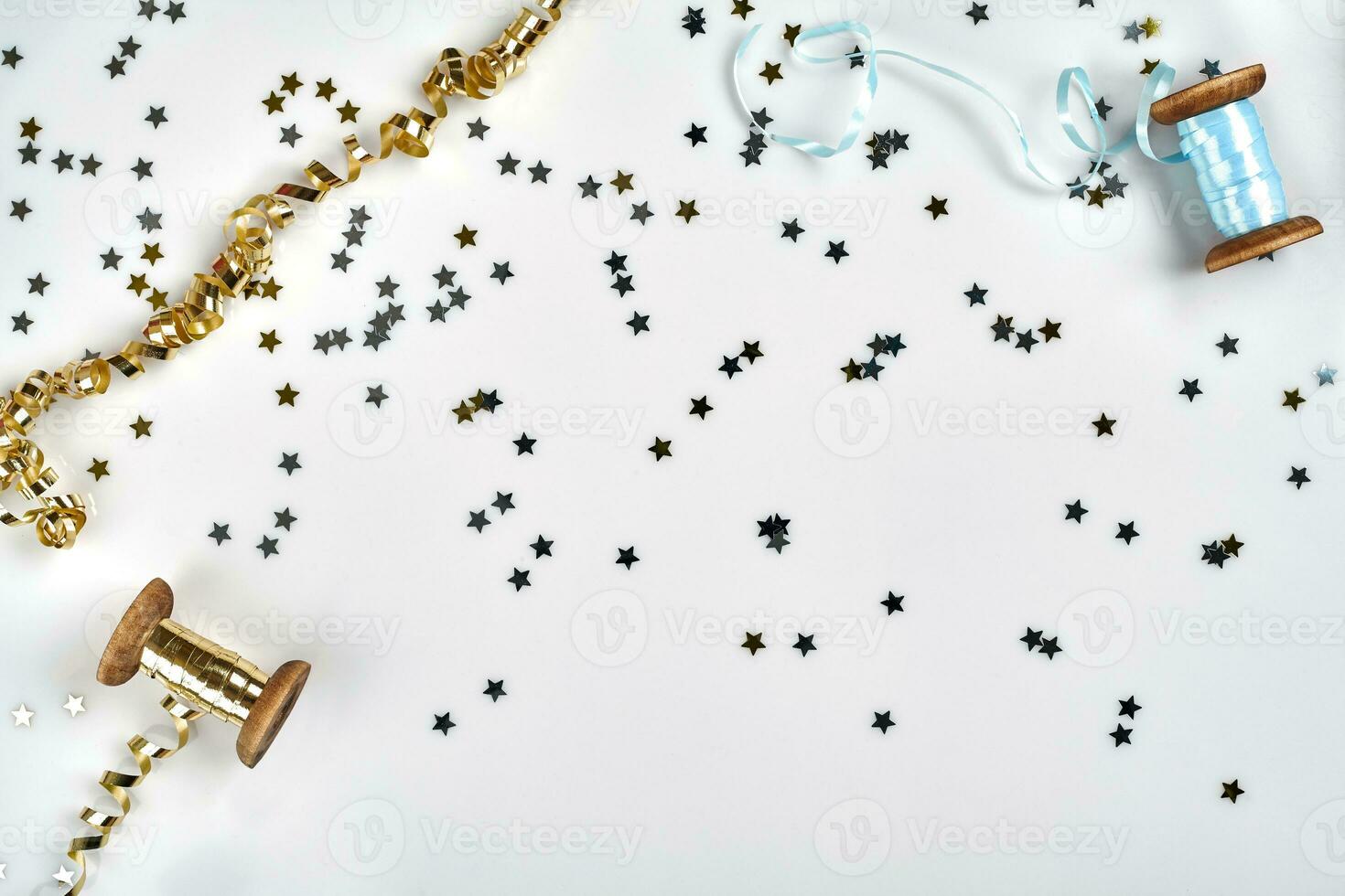 Delicate wavy ribbons and metallic star shaped confetti isolated on white background. Christmas holidays decoration concept. photo