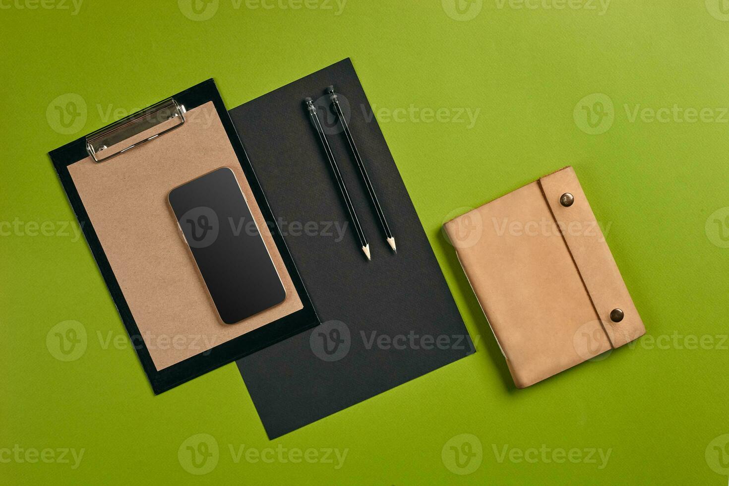 Top view in focus with different office equipment, supplies, stationery. Green background with copy space. Education, workplace concept. Close-up. photo