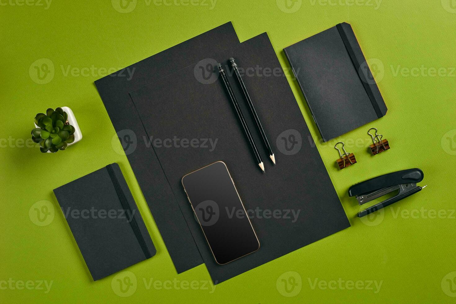 Top view in focus with different office equipment, supplies, stationery. Green background with copy space. Education, workplace concept. Close-up. photo