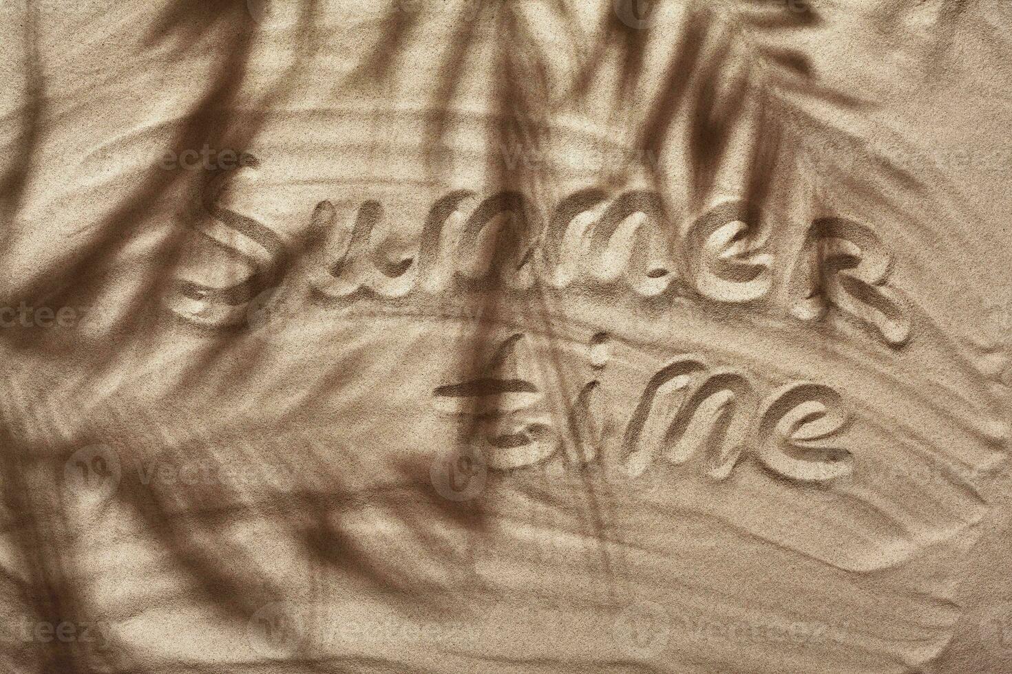 Summer concept with a shadow of a tropical palm tree leaves, copyspace on a white beach sand. photo