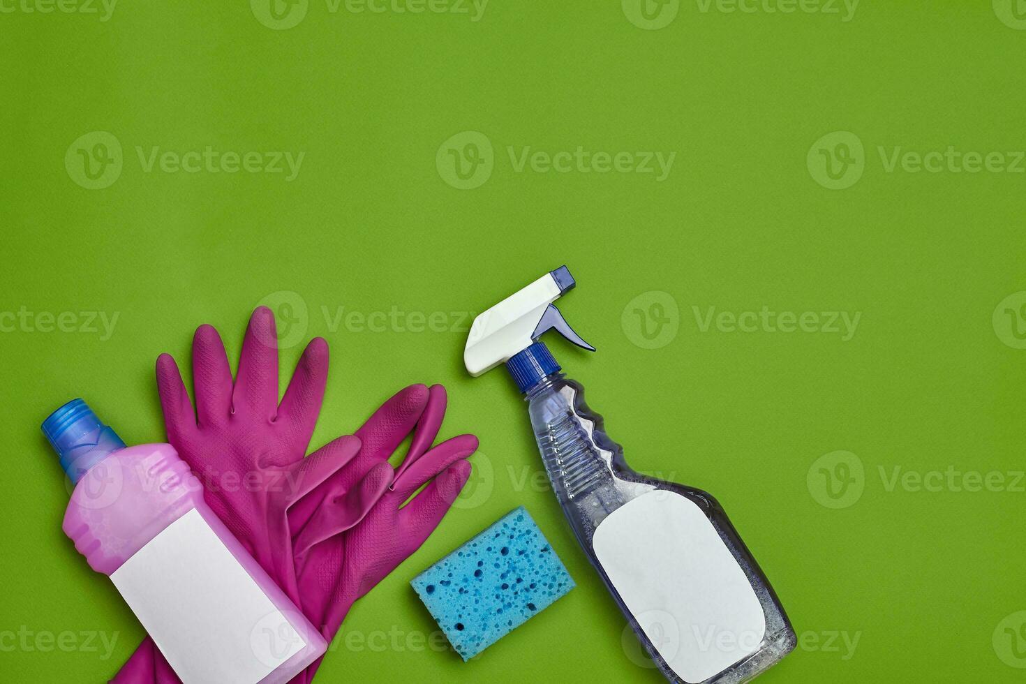 Detergents and cleaning accessories on a green background. Housekeeping concept. photo