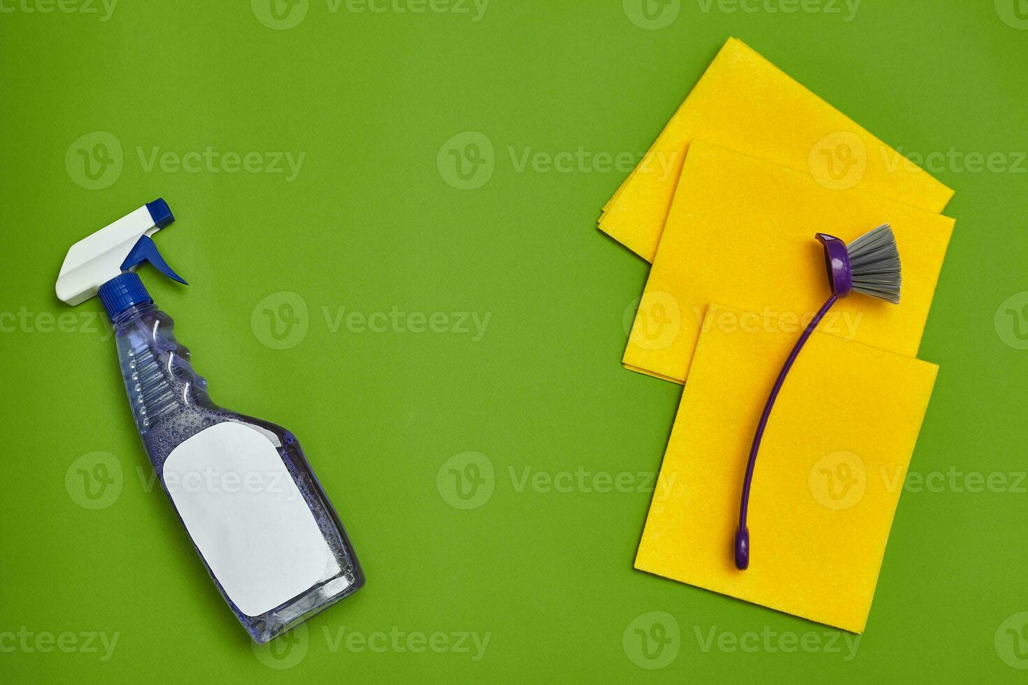 Detergents and cleaning accessories on a green background. Housekeeping concept. photo