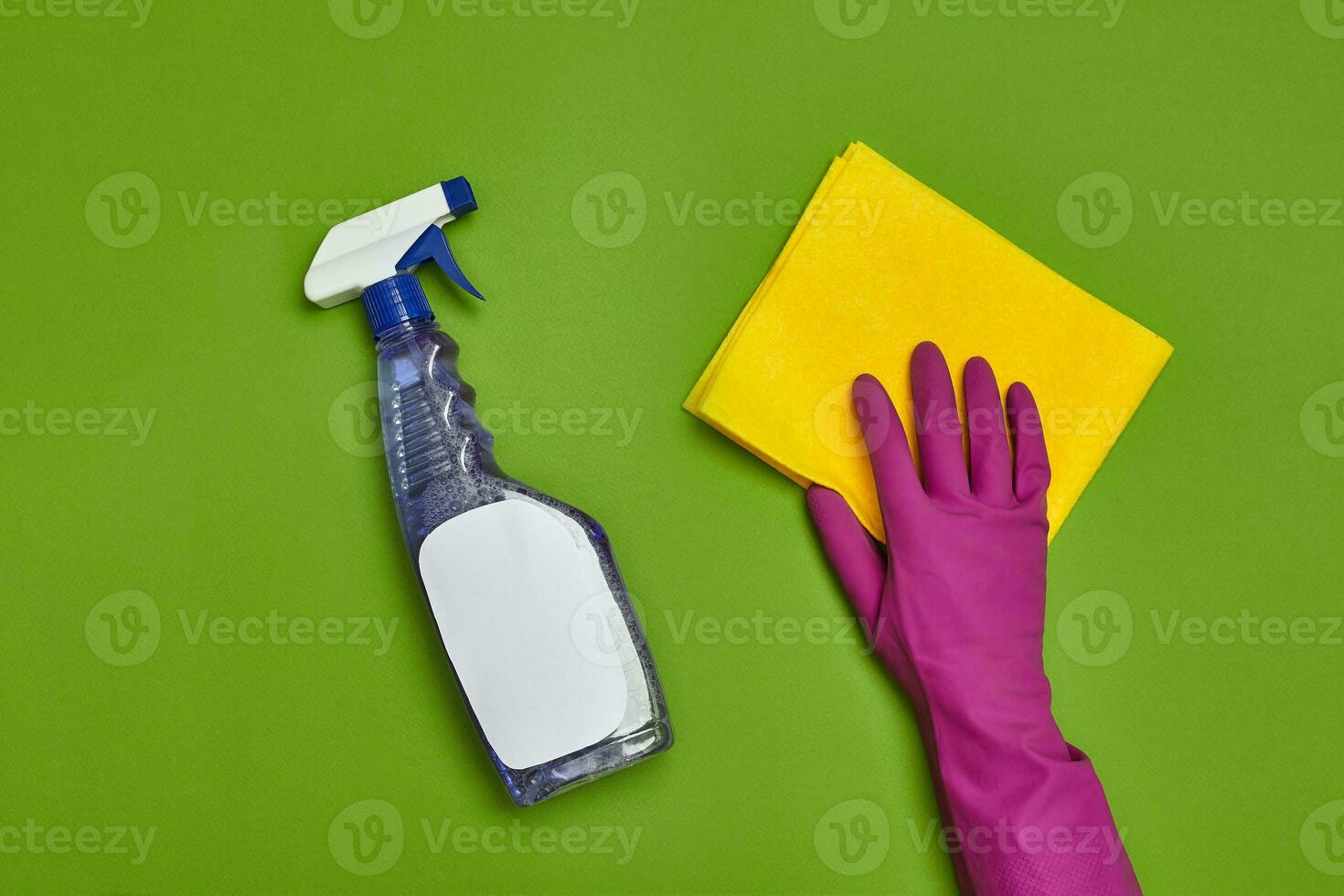 Detergents and cleaning accessories on a green background. Housekeeping concept. photo